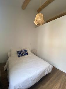 a bedroom with a white bed with a lamp at La Casita Luz in Cavaillon