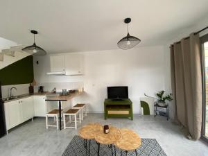 a living room with a table and a kitchen at La Casita Luz in Cavaillon