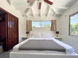 a bedroom with a large bed with a ceiling fan at Salt Nosara in Nosara