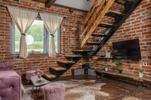 a living room with a brick wall and a tv at Kuća za odmor Kleopatra in Netretić