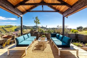 a patio with two blue couches and a table at Obsidian View Lodge in Putiki