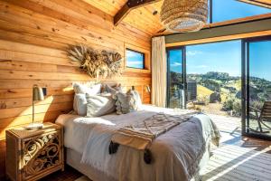 a bedroom with a bed and a large window at Obsidian View Lodge in Putiki