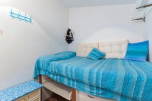 Schlafzimmer mit einem Bett mit blauer und weißer Bettwäsche in der Unterkunft VILLETTA L'ARANCIO in Marina di Campo