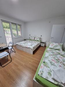 Un dormitorio con dos camas y una mesa y sillas. en Apartments Meshko, en Ohrid