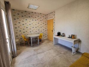 eine Küche mit einem Tisch, einem Tisch und Stühlen in der Unterkunft La Chambre du Saunei in Castelnau-de-Guers