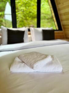 a white towel sitting on top of two beds at GreenWood Cottages Merisi in Merisi