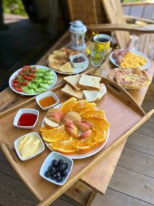 a wooden table with different types of food on it at GreenWood Cottages Merisi in Merisi