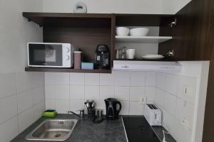 a kitchen with a sink and a microwave at C210 Appartement Disneyland Paris Studio in Montévrain +7 photos