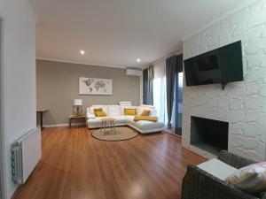 uma sala de estar com um sofá branco e uma lareira em Edard's Great House em Castelldefels