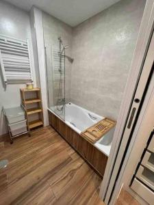 y baño con bañera y ducha acristalada. en Precioso apartamento recién reformado, en Gijón