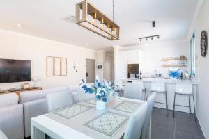 a living room and kitchen with a table and chairs at Midrahov Luxury Apartment in Zikhron Ya‘aqov