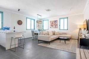 a living room with a couch and a table at Midrahov Luxury Apartment in Zikhron Ya'akov