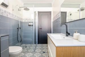 a bathroom with a sink and a toilet and a shower at Midrahov Luxury Apartment in Zikhron Ya‘aqov