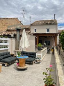 a patio with couches and a table and a house at Cal Robert in Penellas