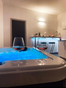 dois copos de vinho sentados numa mesa ao lado de uma piscina em Lavitas SPA em Moravče