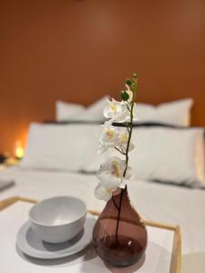 a vase with white flowers on a table with a bowl at Private room in Benton's way in Marshalltown