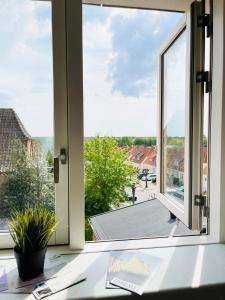 una ventana abierta con vistas al techo en Scandinavian Apartment Hotel - Prison Museum 1- one room apartment, en Horsens