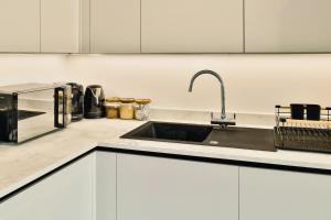 a kitchen with a sink and a microwave at Imagine That Property in Hemel Hempstead