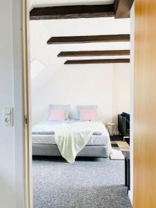 1 dormitorio con 1 cama con almohadas rosas en Scandinavian Apartment Hotel - Prison Museum 1- one room apartment, en Horsens