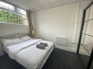 ein Schlafzimmer mit einem Bett mit zwei Handtüchern darauf in der Unterkunft Barnet 1 Spacious 2-Bed Apartment in Barnet