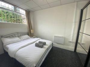 a bedroom with a bed with two towels on it at Barnet 1 Spacious 2-Bed Apartment in Barnet