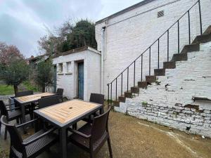 two wooden tables and chairs next to a brick building at Barnet 1 Spacious 2-Bed Apartment in Barnet