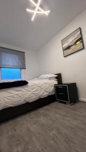 a bedroom with a bed and a fan and a window at Buzz Crib in London