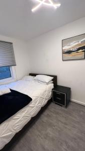 1 dormitorio con 1 cama grande y mesita de noche en Buzz Crib en Londres
