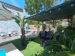 Un patio con césped con sillas y sombrilla. en Edard's Great House, en Castelldefels