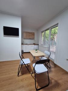 een kamer met een tafel en stoelen en een keuken bij Apartments Meshko in Ohrid