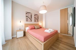 sypialnia z łóżkiem z drewnianą ramą łóżka w obiekcie Acogedor apartamento en centro histórico Malaga w Maladze