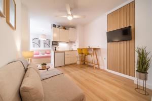 salon z kanapą i kuchnią w obiekcie Acogedor apartamento en centro histórico Malaga w Maladze