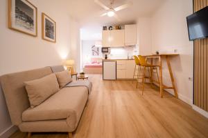 salon z kanapą i kuchnią w obiekcie Acogedor apartamento en centro histórico Malaga w Maladze