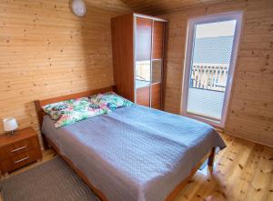 a bedroom with a bed and a window in a cabin at Apartamenty Przy Deptaku in Trzęsacz