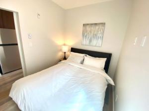 een slaapkamer met een groot wit bed en een lamp bij Lovely Brand New Suite in Sidney