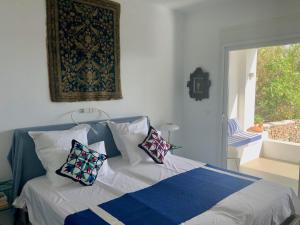 a bedroom with a bed with pillows and a window at Kokkali Beachfront Villa Leros in Gourna