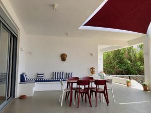 a dining room with red chairs and a table at Kokkali Beachfront Villa Leros in Gourna