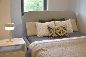 Un dormitorio con una cama con almohadas. en Green Estate Old Town Apartment, private parking, balcony, en Gdansk