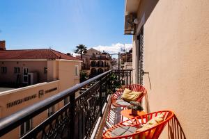 a balcony with two chairs and a table on a balcony at Melos House in Zakynthos Town