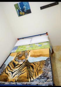 a bed with a painting of a tiger on it at Hospedaje Hermanos Cardona in Armenia