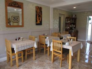 jadalnia ze stołami, krzesłami i lustrem w obiekcie Whitaker Lodge Bed & Breakfast w mieście Castlepollard