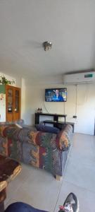 a living room with a couch and a flat screen tv at Casa Guadalupe in Santo Tomé