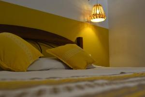 um quarto com uma cama com paredes amarelas e um lustre em ¡Hermosa Estancia Centro de Oaxaca! em Oaxaca de Juárez