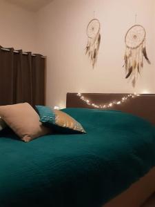 a bedroom with a bed with green sheets and lights at NIDO TRA GLI ULIVI in Finale Ligure