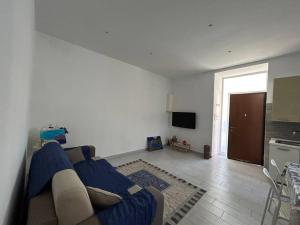 a living room with a blue couch and a kitchen at casa Vesuvio in Cercola