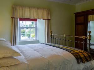 a bedroom with a bed and a window at Craigvar House in Castle Douglas