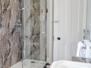 a bathroom with a glass shower with a sink at Craigvar House in Castle Douglas