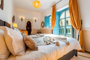 a bedroom with a bed and a large window at Riad L'orange Bleue in Marrakesh