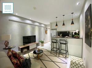 a living room with a couch and a kitchen at Flat Luxuoso-Piscina, Praia e Serviço de Camareira in Salvador