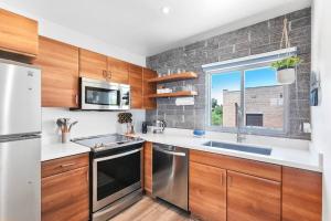 a kitchen with wooden cabinets and stainless steel appliances at DTPH Modern Designer Studio - Pool & Parking - in Phoenix